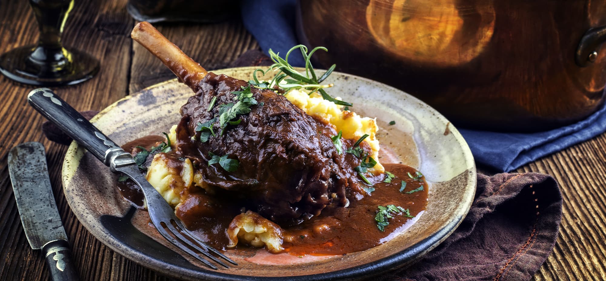 Lamb shanks with gravy underneath and mash potato is pictured